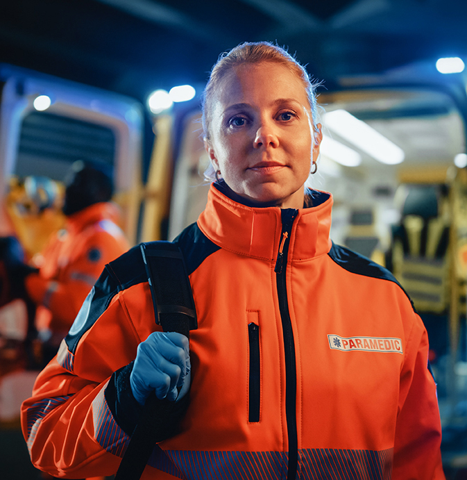 portrait of a femail EMT on the scene with ambulance in the back. Frustrated public worker