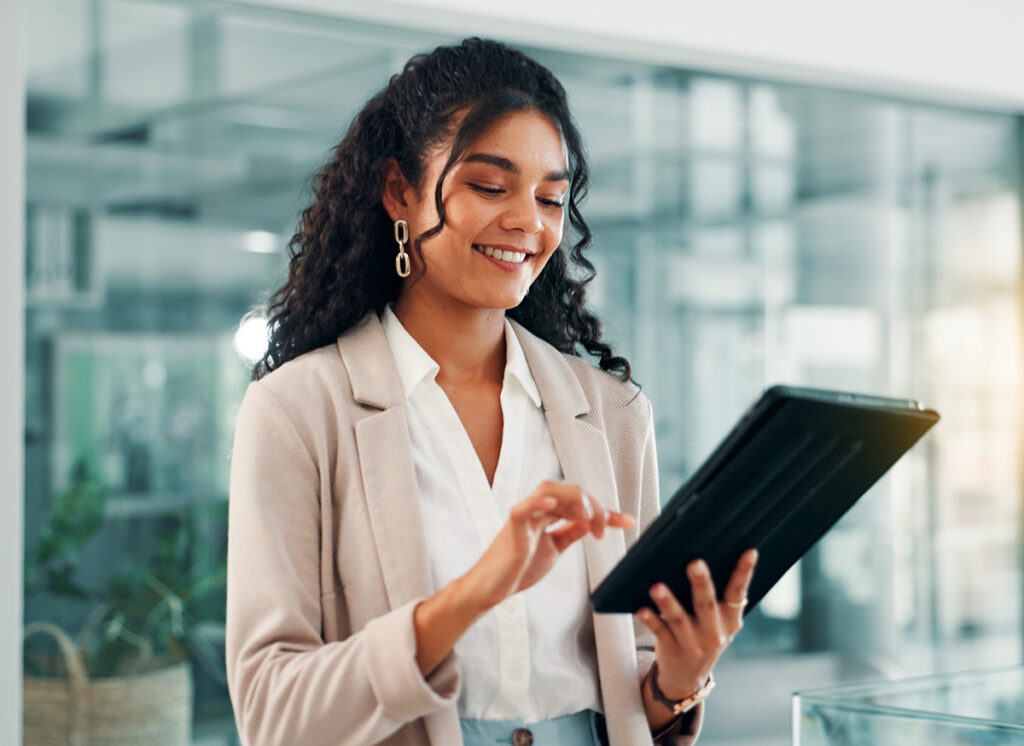 Woman confidently finding answers on an iPad, in a modern office setting